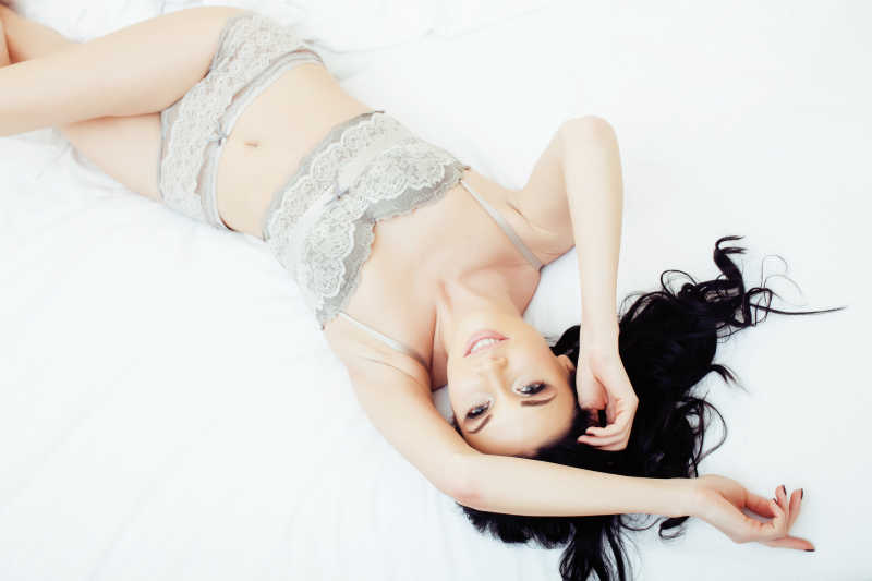 性感的穿灰色内衣的躺在床上的黑发女人
