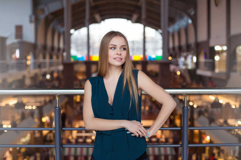 栏杆前年轻漂亮的微笑的女商人