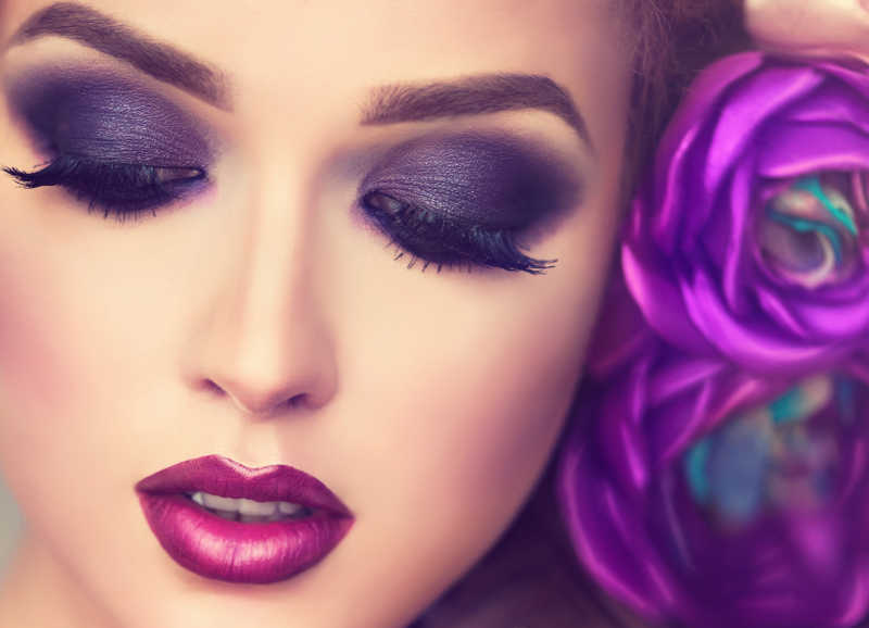 紫色妆容的女人头上戴花