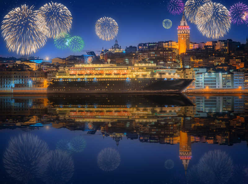 海面上的游船和城市上空的烟花