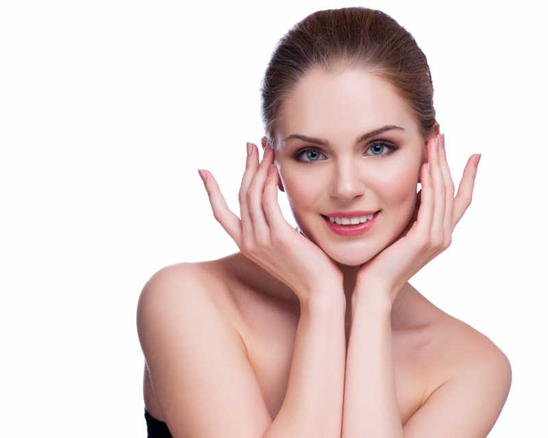 美丽的抚摸着脸的年轻女子