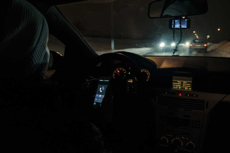 冬季道路上车内打手机的女人