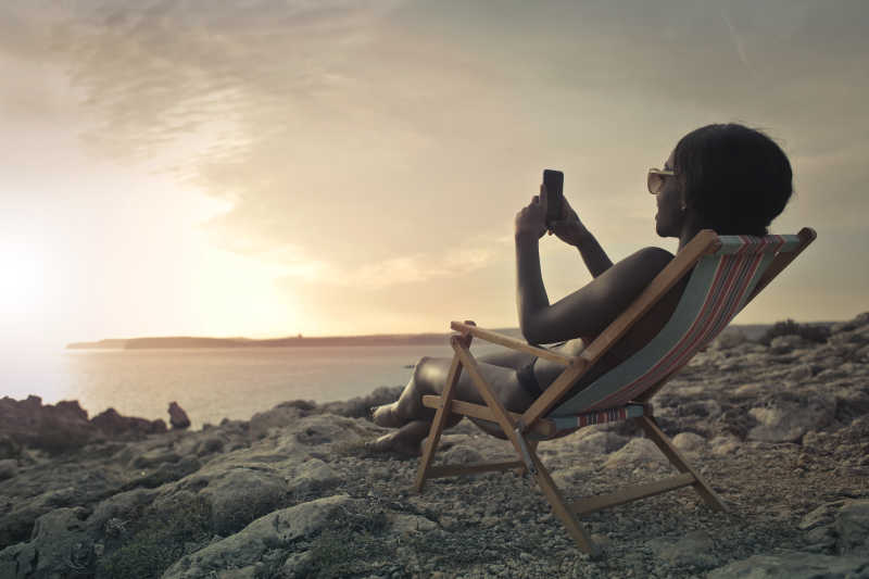 海滩度假的美女在拿手机聊天