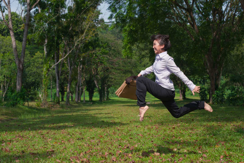 在草坪上跳舞的女商人