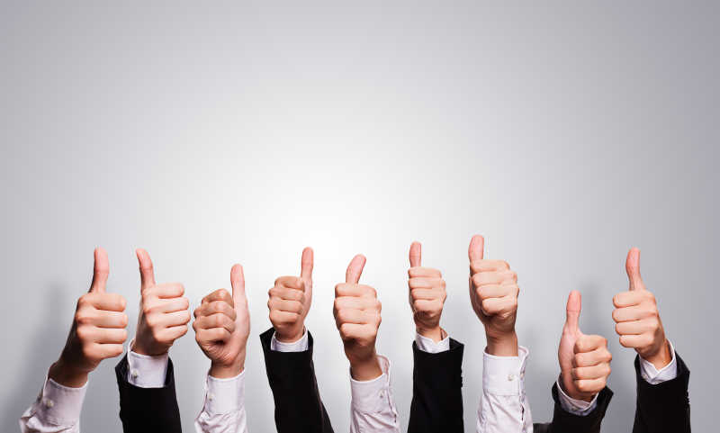 灰色背景下商业团队竖起大拇指