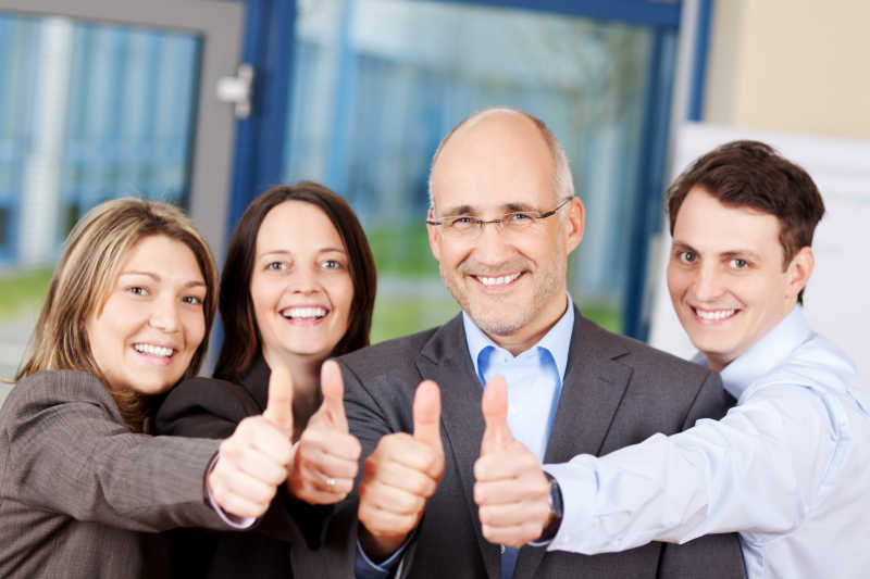 商业人士在公司竖起大拇指的手势