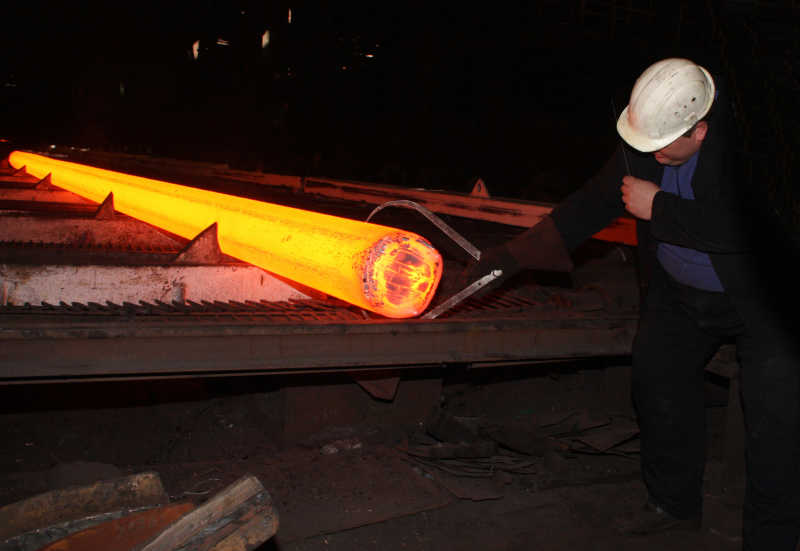 轧钢厂工人在检验层压钢的质量