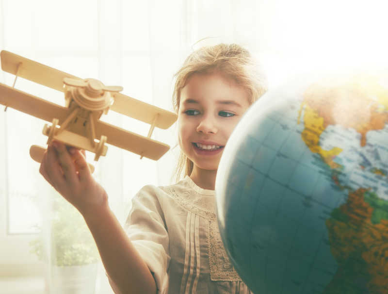 手拿木制飞机的女孩在地球仪旁图片 地球仪旁的孩子手拿木制飞机素材 高清图片 摄影照片 寻图免费打包下载
