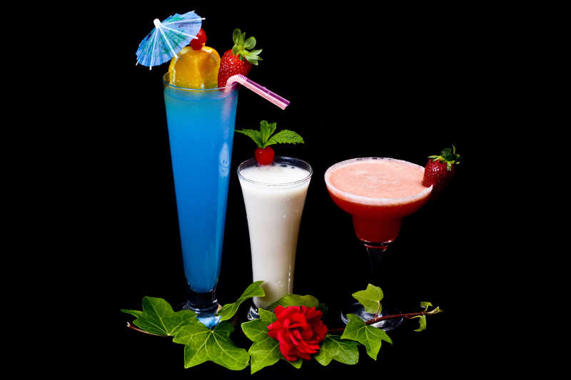 黑色背景下有花朵装饰的鸡尾酒