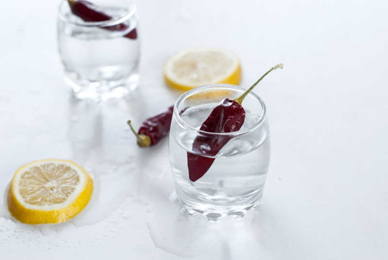 白木桌子的两杯伏特加和柠檬片