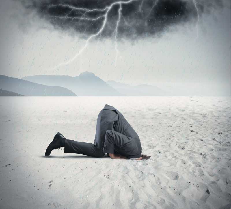 男性商人把头埋在沙漠中