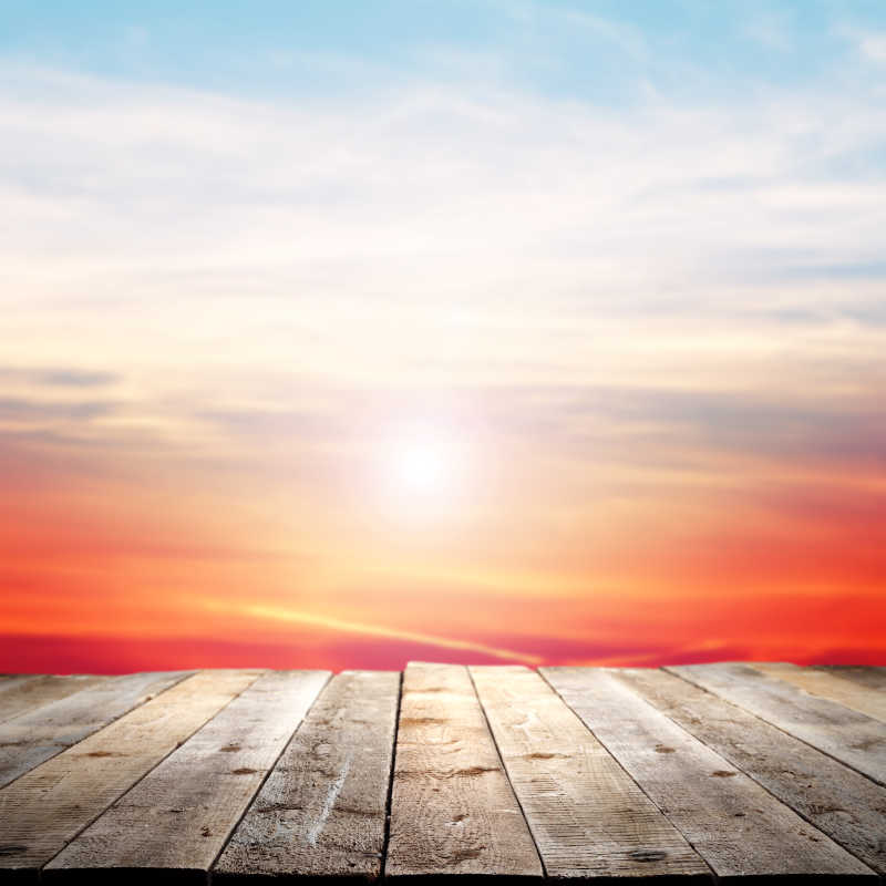 夕阳火烧云背景前的木桌