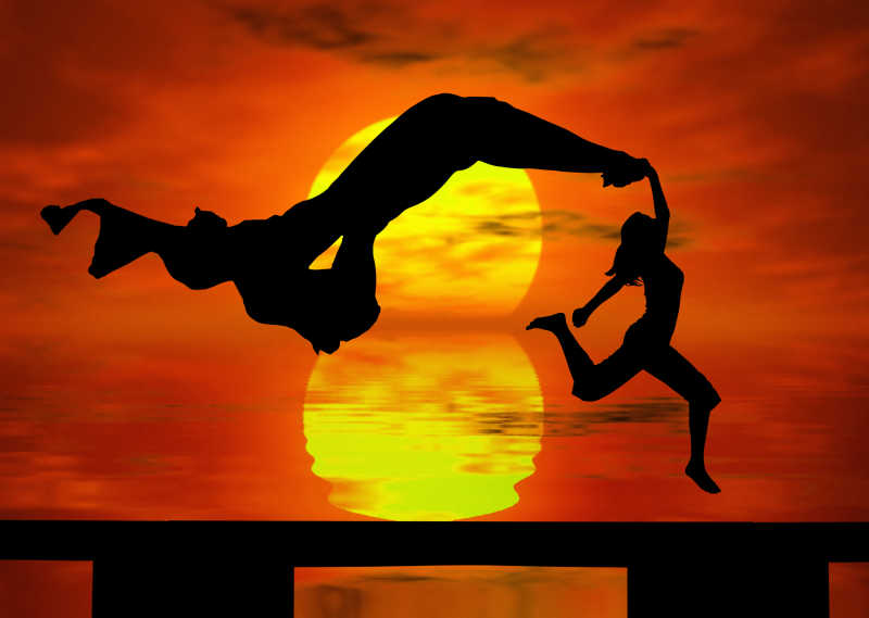 夕阳下的女孩在海边跳跃