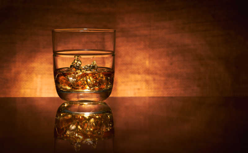 没有边缘突出的在橙色背景上的玻璃酒杯