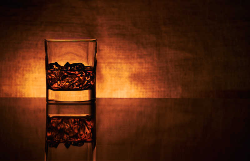 橙色背景上没有边缘突出的玻璃酒杯