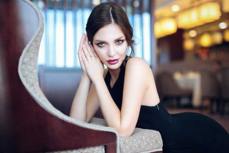 趴在沙发上穿着黑色礼服的性感美女