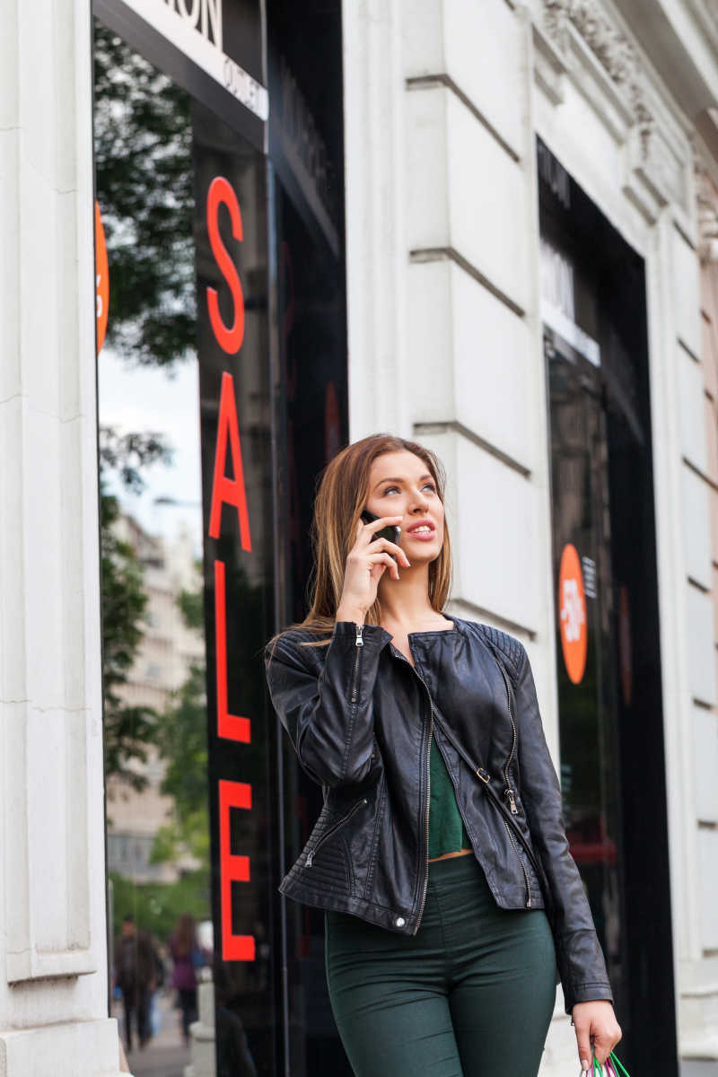 美女在商店门口打电话