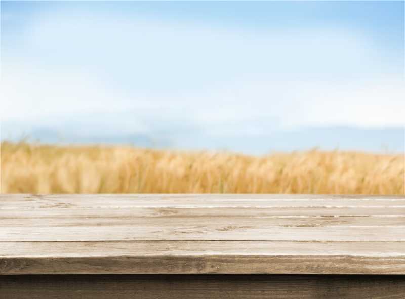 金色麦田背景前的木桌