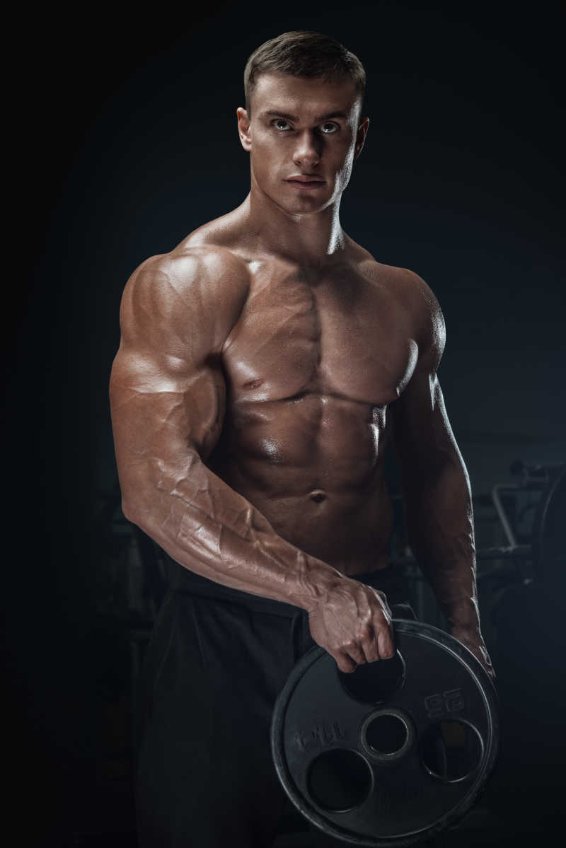 自信英俊的年轻男子用杠铃练习