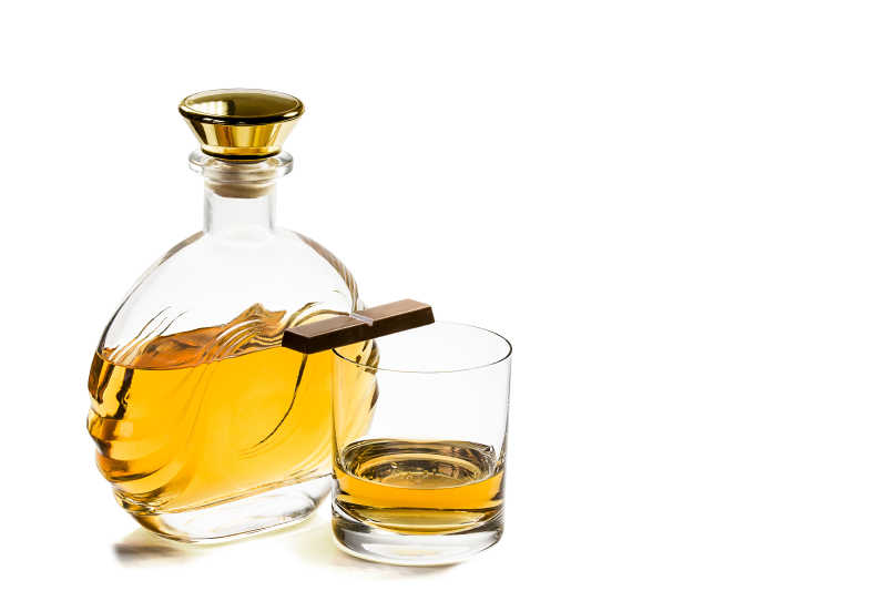 巧克力和瓶子和一杯威士忌在白色背景下
