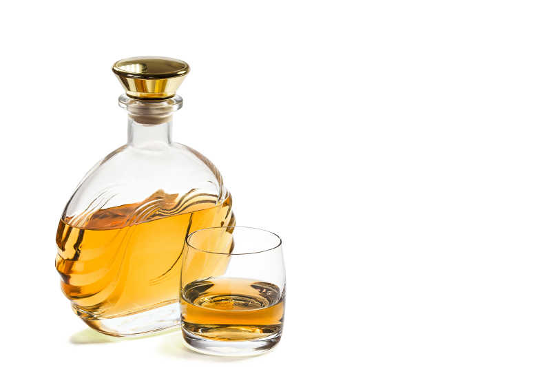 白色背景下的瓶和玻璃的威士忌
