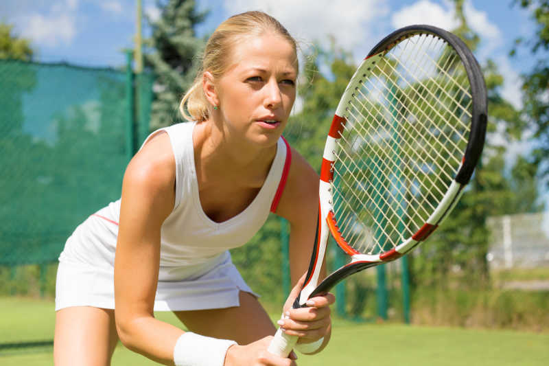 女人在网球场打网球