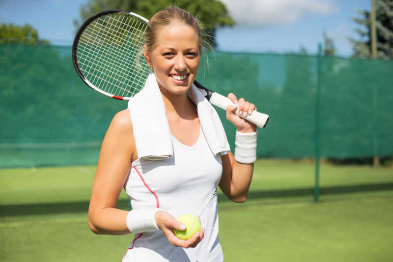微笑的女运动员在网球场