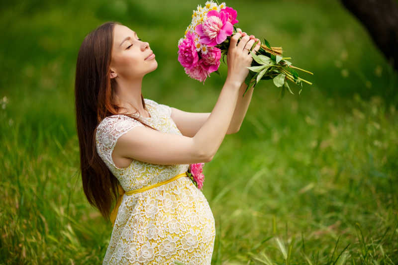 户外捧着花束的孕妇