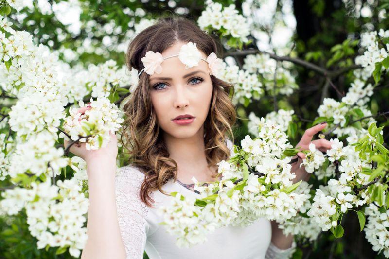 漂亮女人在一棵开花的苹果树前