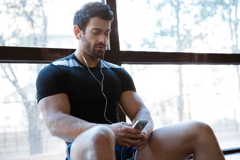 坐在窗台上听音乐的运动帅哥