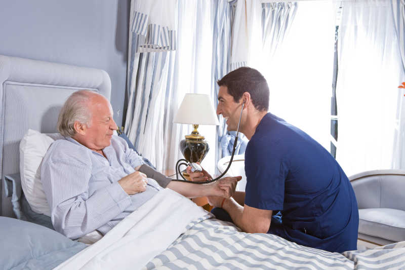 给老人进行听诊的男护士