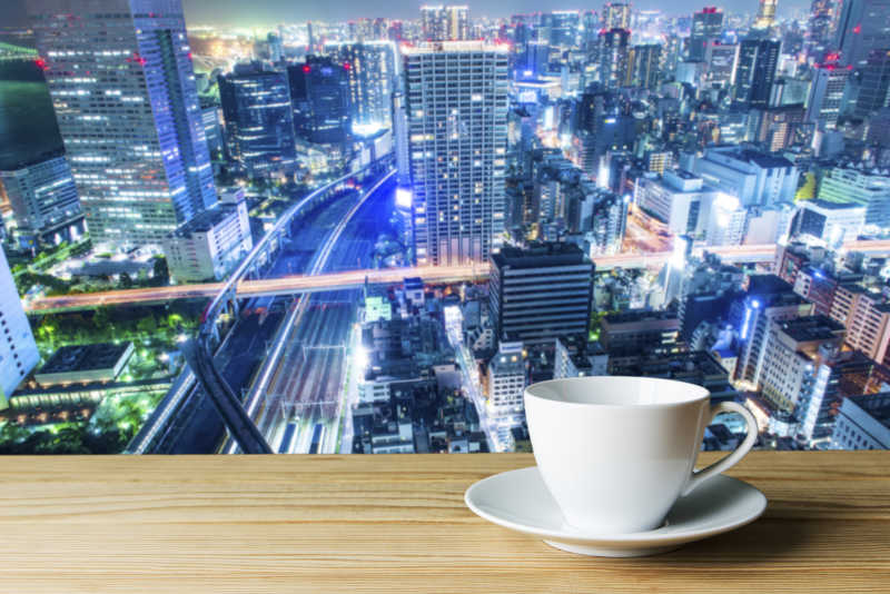 城市夜景建筑背景前的白色咖啡杯