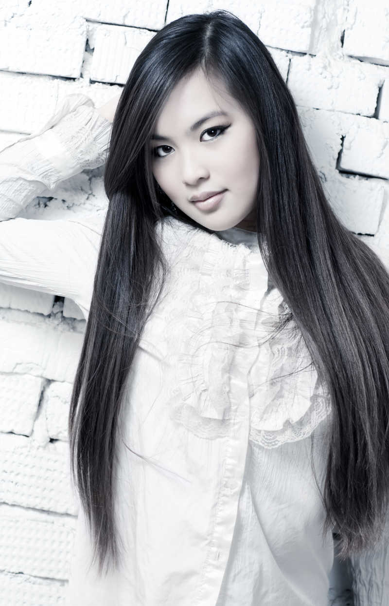 明亮的白色背景墙上的年轻女子