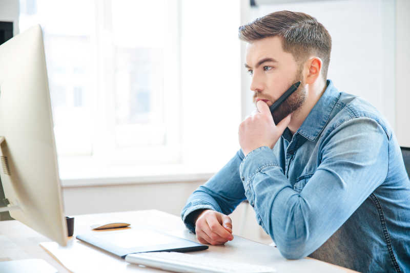 坐在电脑前陷入思考的设计师