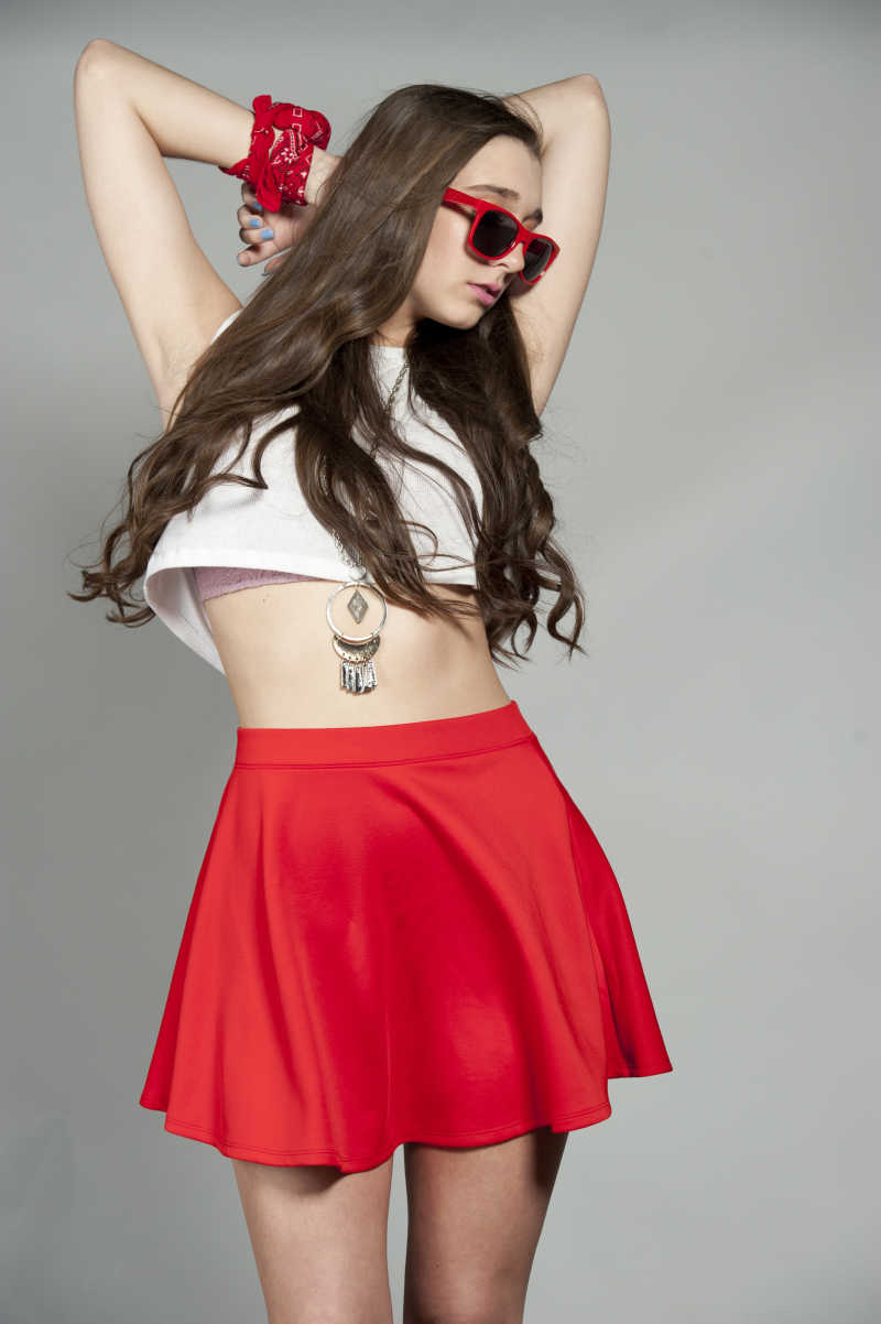 灰色背景下穿着红色短裙的美女