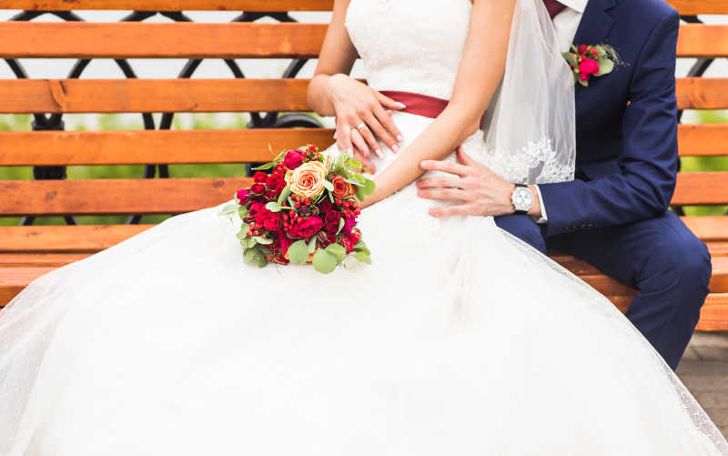 坐在长椅上新娘手里的捧花