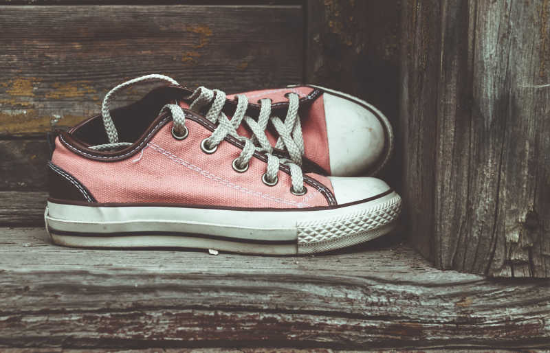 放在木板上的红色帆布鞋