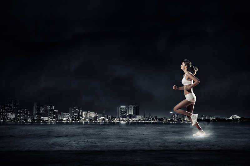 黑色背景下跑步的女运动员