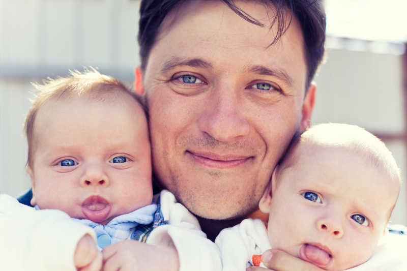 父亲抱着双胞胎婴儿