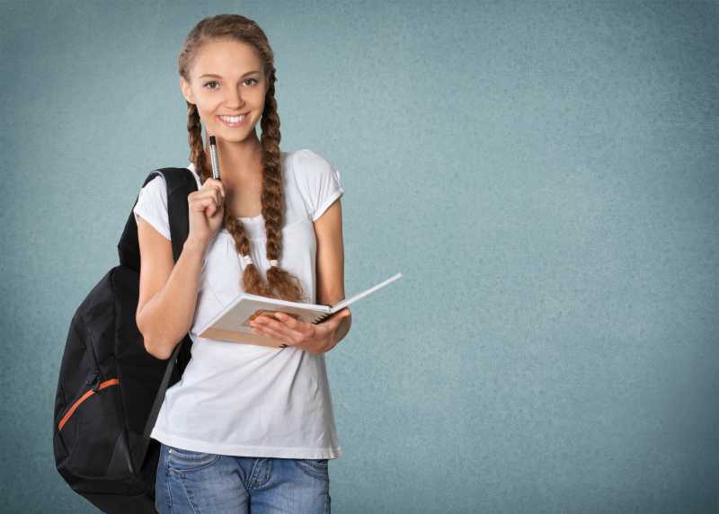 灰色背景下看书的女学生