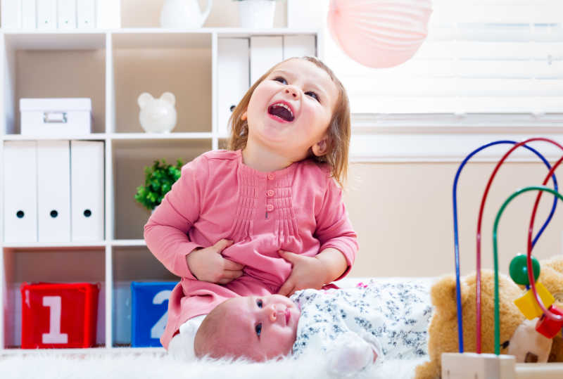 女孩和她的新生妹妹开心的玩耍