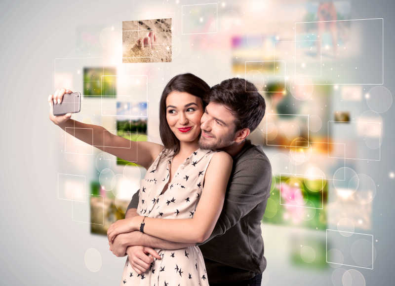 照片背景与手机自拍爱以幸福的年轻夫妇收集记忆的概念