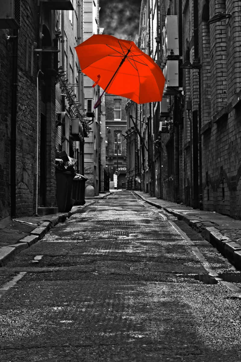 黑暗的城市小巷里的红色雨伞