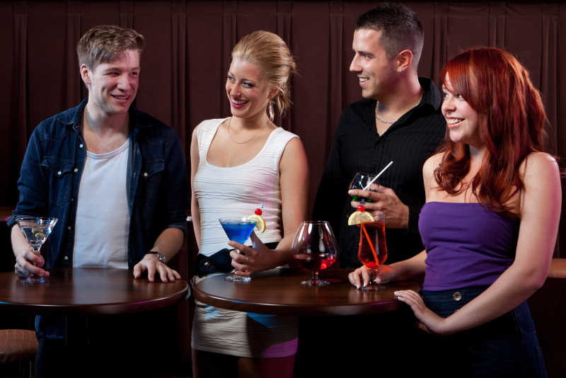 黑色背景下在酒吧玩的开心的朋友们