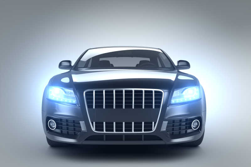 灰色背景下开着灯光的汽车