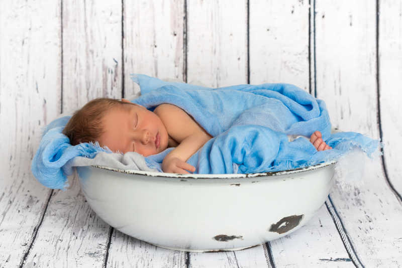 可爱的被裹着蓝色毯子的小婴儿