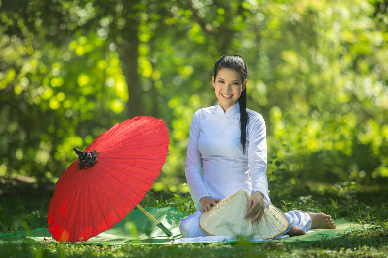 坐在一个绿色垫子上的越南美女