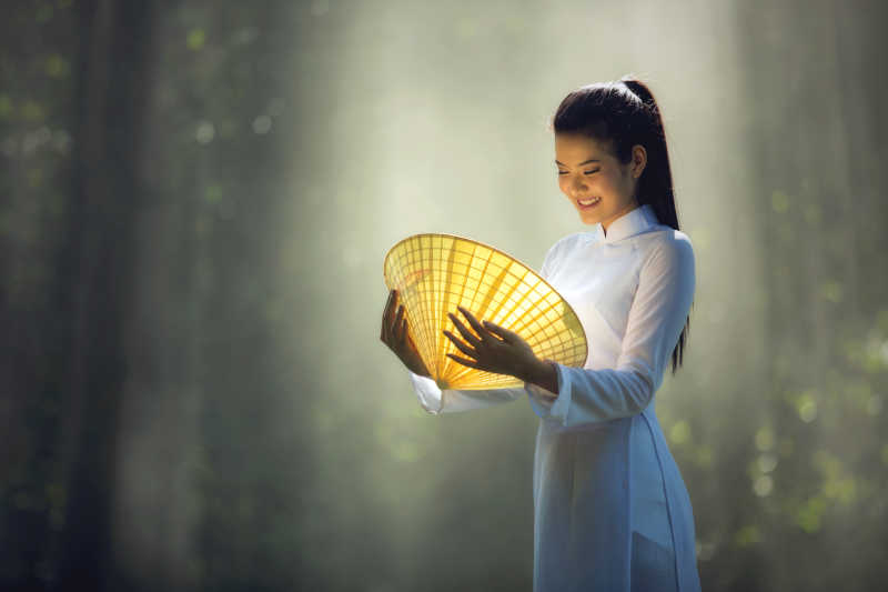 越南美女手里拿着一个发光的帽子