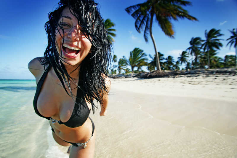 海滩上可爱的顽皮黑发女人