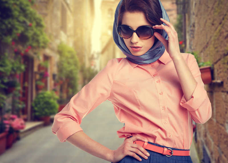 优雅的女人带着行李箱走在意大利城市的街道上